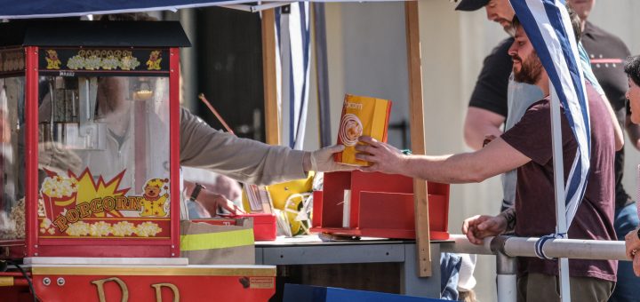 Popcorn-Stand des Fördervereins am Spieltag. Ein Mann bekommt gerade seine Portion Popcorn überreicht.